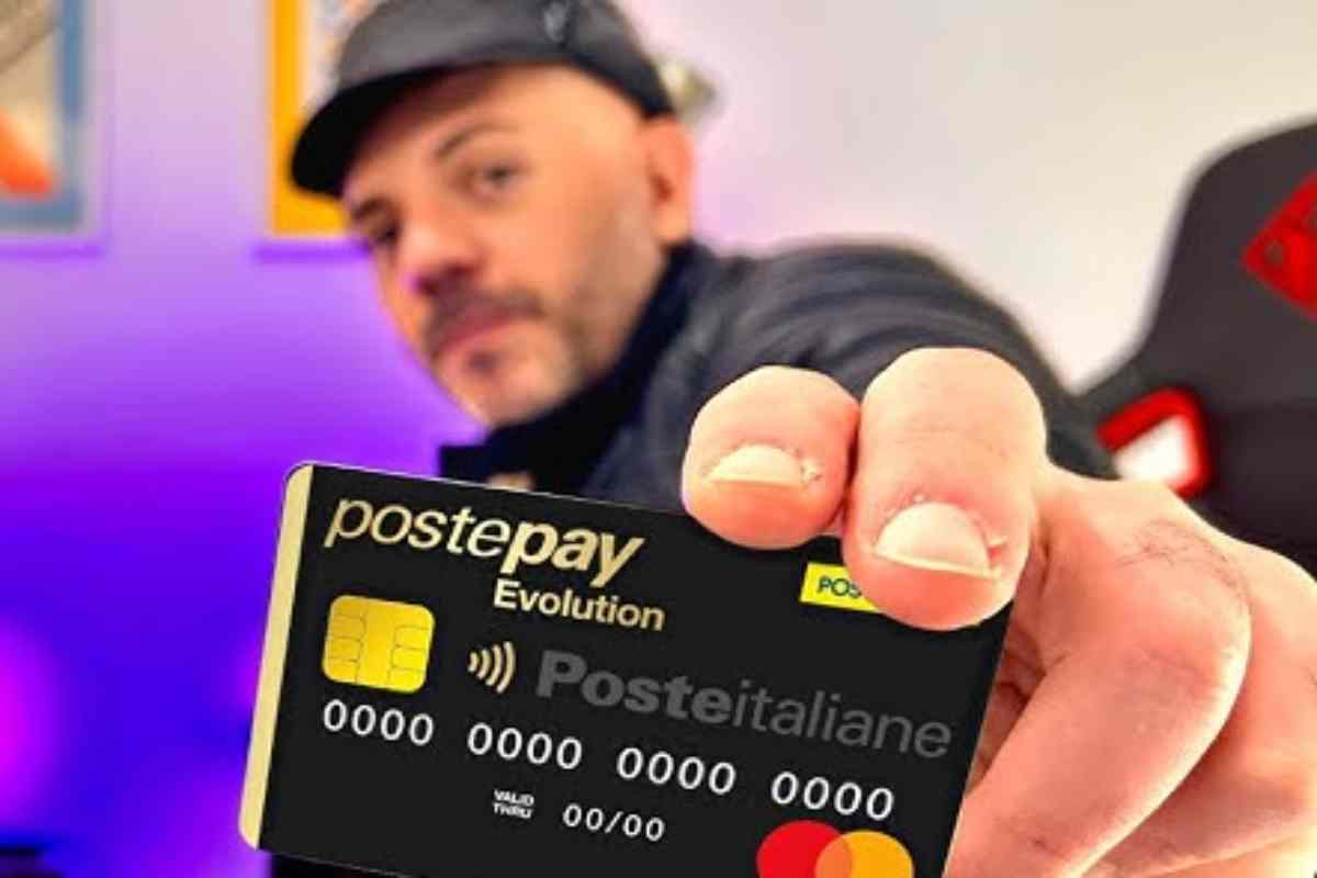 un ragazzo tiene tra le dita una postepay